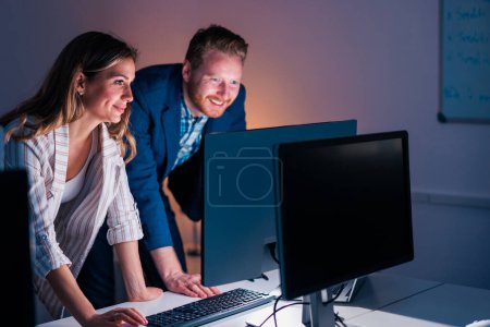 Photo for Business colleagues working overtime in an office, reviewing documents and collaborating on new project - Royalty Free Image