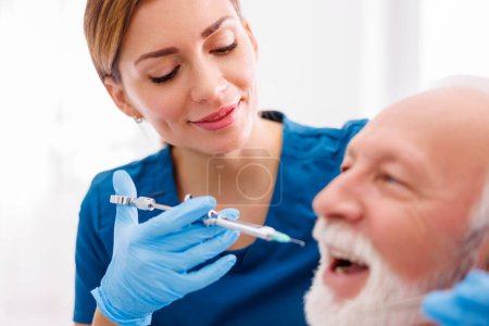 Zahnarzt mit lokaler Betäubung des Patienten zur Betäubung des Schmerzes vor dem Eingriff