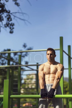 Téléchargez les photos : Musclé construit jeune athlète travaillant dans une salle de gym extérieure - en image libre de droit