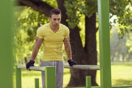Foto de Atleta joven musculoso construido haciendo ejercicio en un gimnasio al aire libre - Imagen libre de derechos