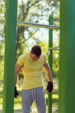 Téléchargez les photos : Musclé construit jeune athlète travaillant dans une salle de gym extérieure - en image libre de droit