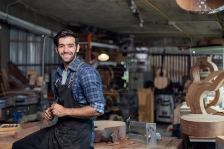 Téléchargez les photos : Portrait de luthier guitare propriétaire de petite entreprise en salle de travail, concept d'art et d'artisanat - en image libre de droit