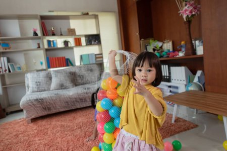 Foto de Feliz asiático pequeño niño tener divertido niño coleccionar plástico juguete bolas - Imagen libre de derechos