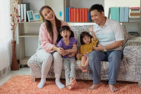 Foto de Feliz asiática familia madre y padre con dos hijas jugando juntos en casa - Imagen libre de derechos
