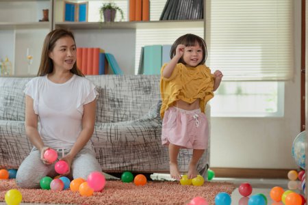 Foto de Feliz asiática familia madre y niño hija son jugando colorido bolas - Imagen libre de derechos