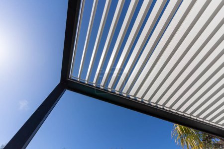 Pergola en aluminium pour patio extérieur contre ciel bleu clair. Vue du bas