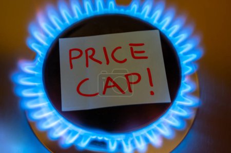 Téléchargez les photos : Brûleur à gaz lumineux, avec lettrage Price Cap. Introduction d'une limite de prix du gaz en Europe. - en image libre de droit