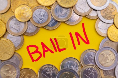 Photo for Word Bail-in, and coins around. Bank failure rescue system. - Royalty Free Image