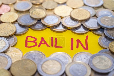 Photo for Word Bail-in, and coins around. Bank failure rescue system. - Royalty Free Image