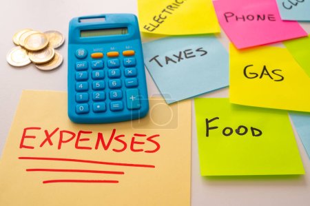 Photo for Yellow sheet, with red text "expenses", with calculator next to it and colored sticker sheets with list of expenses. Increases and cost of living. - Royalty Free Image