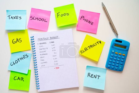 Photo for Notepad, with monthly expenses, and next to it a calculator and colored adhesive sheets with a list of expenses. Increases and cost of living. - Royalty Free Image