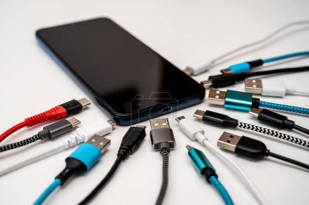 Photo for Smartphones, cables and USB plugs of different types. Evolution and types of USB plugs. - Royalty Free Image