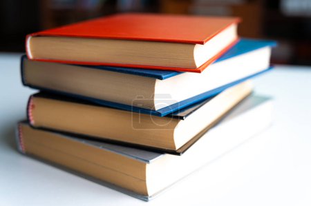 Foto de Montón de libros, fotografiados de cerca, sobre una superficie blanca. - Imagen libre de derechos