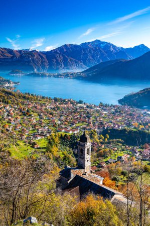 Photo for Lake Como photographed from Ossuccio, showing mountains, Bellagio, the town of Ossuccio, and the Church of the Madonna del Soccorso, in autumn. - Royalty Free Image
