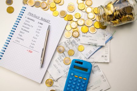 Photo for Notebook with family budget, calculator, receipts and coins next to it. Price increases and economic difficulties. - Royalty Free Image