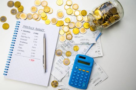 Notizbuch mit Familienbudget, Taschenrechner, Quittungen und Münzen daneben. Preiserhöhungen und wirtschaftliche Schwierigkeiten.