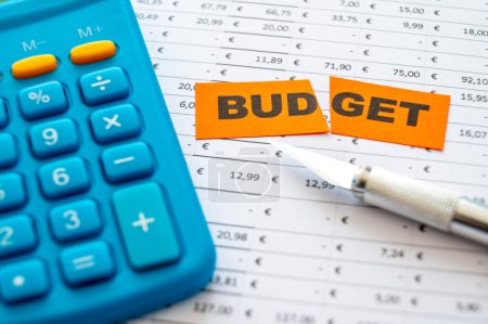Tableau avec budget, dépenses, recettes et billet avec texte Budegt coupé en deux. Réduction budgétaire.