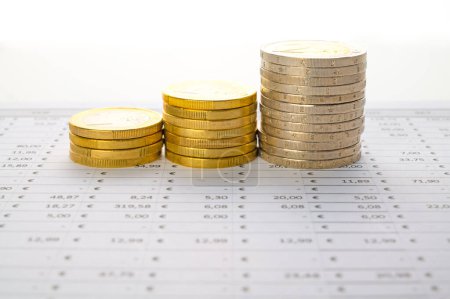 Tabelle mit Berechnungen, Budget und Stapeln von Münzen; Erhöhung oder Verringerung von Geld oder Budget.