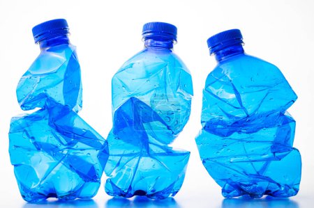 Plastic bottles, blue and transparent, crushed. Waste and plastic pollution, plastic recycling. 