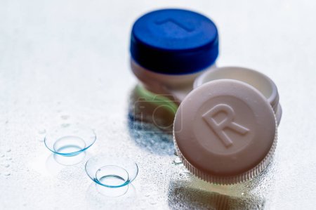 Photo for Contact lenses, and case, on mirror surface, with water drops. - Royalty Free Image