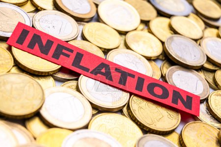 Fondo de monedas en euros y billete rojo con texto Inflación.