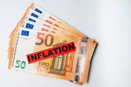 Euro banknotes background, with red ticket with text Inflation.