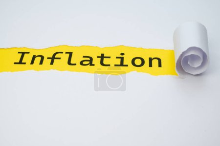 Photo for Yellow surface, with the word Inflation in black, underneath torn and rolled white cardboard. - Royalty Free Image