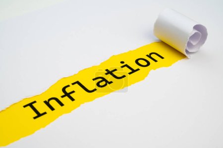 Photo for Yellow surface, with the word Inflation in black, underneath torn and rolled white cardboard. - Royalty Free Image