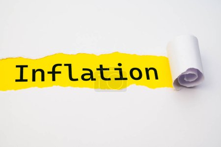 Surface jaune, avec le mot Inflation en noir, sous le carton blanc déchiré et roulé.