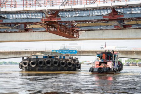 Foto de Un barco de transporte en el camino en el puente Rama 7 en el río Chao Phraya en la ciudad de Bangkok en Tailandia. Tailandia, Bangkok, diciembre de 2022 - Imagen libre de derechos