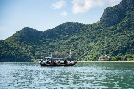 Téléchargez les photos : Un bateau de randonnée dans le paysage de la plage et de la côte à Dolphin Bay au chapeau Sam Roi Yot dans la province de Prachuap Khiri Khan en Thaïlande, Thaïlande, Hua Hin, Décembre, 2022 - en image libre de droit