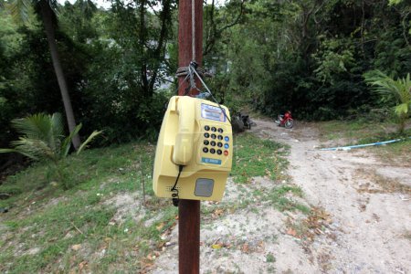 Téléchargez les photos : Un téléphone sur une route sur l'île Ko Tao dans la province de Surat Thani en Thaïlande, Thaïlande, Ko Tao, Mars 2010 - en image libre de droit