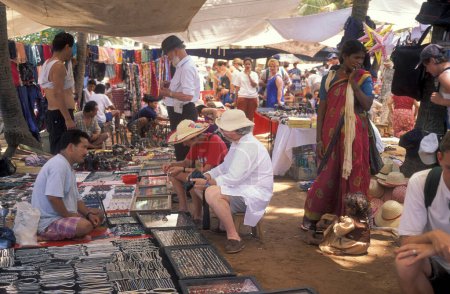 Téléchargez les photos : Commerces et touristes à l'ancien marché aux puces d'Anjuna sur la côte de la ville d'Anjuna dans la province de Goa en Inde, Inde, Goa, avril 1996 - en image libre de droit