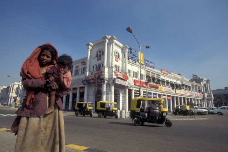 Photo for A poor women with child at the shopping area of Connaught Place in the city of New Delhi in India.  India, Delhi, Februar, 1998 - Royalty Free Image