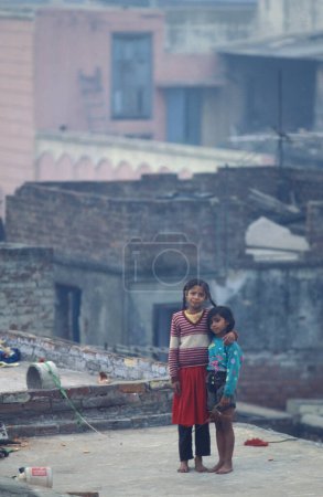 Foto de Dos niñas en una azotea en el casco antiguo de Nueva Delhi en la ciudad de Delhi en la India. India, Delhi, February, 1998 - Imagen libre de derechos