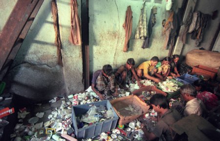 Photo for A recycling factory in a fabric house at a village of a slum in the city centre of Mumbai in India.  India, Mumbai, March, 1998 - Royalty Free Image