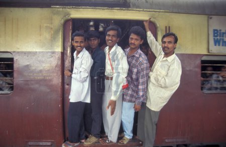 Téléchargez les photos : Un train surchargé sur le chemin de la gare de Mumbai ou Chhatrapati Shivaji Terminus dans le centre-ville de Mumbai en Inde. Inde, Mumbai, mars 1998 - en image libre de droit