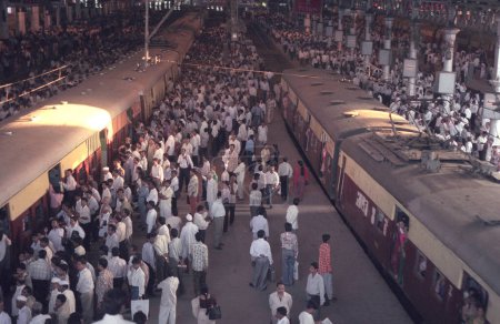 Téléchargez les photos : Personnes et trains à l'intérieur de la gare de Mumbai ou du terminus Chhatrapati Shivaji dans le centre-ville de Mumbai en Inde. Inde, Mumbai, mars 1998 - en image libre de droit