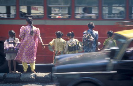 Téléchargez les photos : A Les femmes avec des enfants aiment traverser une route avec la circulation et les gens dans le centre-ville de Mumbai en Inde. Inde, Mumbai, mars 1998 - en image libre de droit
