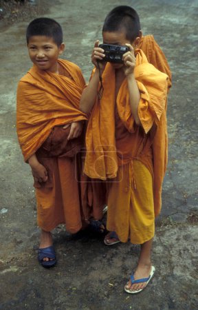Téléchargez les photos : Jeune moine à la fête de la source et de l'eau près de la ville de Jinghong à Xishuangbanna dans la région de la province du Yunnan en Chine en Asie orientale. Chine, Yunnan, avril 1996 - en image libre de droit