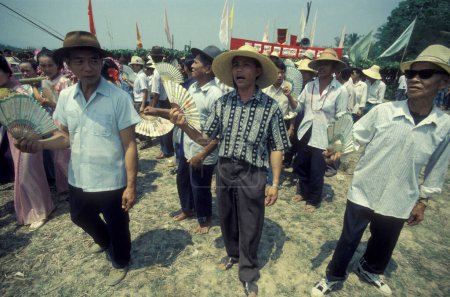 Téléchargez les photos : Personnes au festival de printemps et de fusée Buon Bang Fai près de la ville de Jinghong à Xishuangbanna dans la région de la province du Yunnan en Chine en Asie de l'Est. Chine, Yunnan, avril 1996 - en image libre de droit