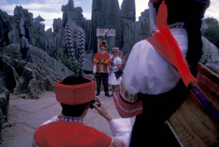 Téléchargez les photos : Personnes en costume traditionnel des minorités chinoises posant au parc Shilin Stone Fosrest près de la ville de Kunming dans la province du Yunnan en Chine en Asie de l'Est. Chine, Yunnan, avril 1996 - en image libre de droit