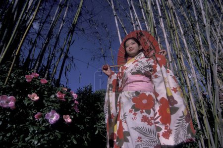 Téléchargez les photos : Personnes en costume traditionnel des minorités chinoises posant au parc Shilin Stone Fosrest près de la ville de Kunming dans la province du Yunnan en Chine en Asie de l'Est. Chine, Yunnan, avril 1996 - en image libre de droit