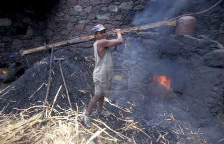 Téléchargez les photos : Un homme travaille dans une distellerie de rhum dans une plantation de canne à sucre près de la ville de Ribeira Grande sur l'île de Santo Antao sur les îles du Cap-Vert en Afrique. Cap-Vert, Santo Antao, mai 2000 - en image libre de droit