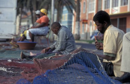 Téléchargez les photos : Pêcheurs fixer la résille en face du marché aux poissons dans la ville de Mindelo sur l'île de Sao Pedro sur les îles du Cap-Vert en Afrique. Cap-Vert, Santiago, mai 2000 - en image libre de droit