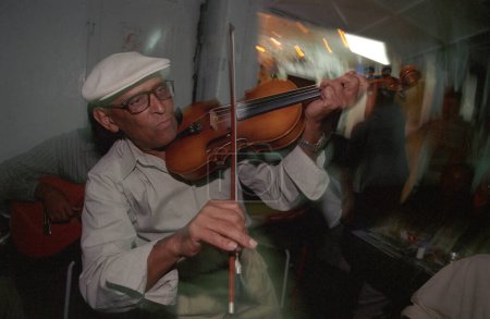 Téléchargez les photos : Musicien jouer Morna traditionnelle ou Cap-Vert Fado dans un restaurant dans la ville Mindelo sur l'île de Sao Pedro sur les îles du Cap-Vert en Afrique. Cap-Vert, Santiago, mai 2000 - en image libre de droit