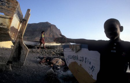 Téléchargez les photos : Les femmes prient la mer dans un village de pêcheurs et bateaux de pêche sur la côte près de la ville de Ponta do Sol sur l'île de Santo Antao sur les îles du Cap-Vert en Afrique. Cap-Vert, Santo Antao, mai 2000 - en image libre de droit