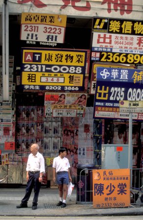 Foto de Personas frente a una pared con anuncios de propiedad y anuncios de propiedad, casas y habitaciones en el centro de Hong Kong en la ciudad de Hong Kong en Hong Kong. China, Hong Kong, mayo de 1997 - Imagen libre de derechos