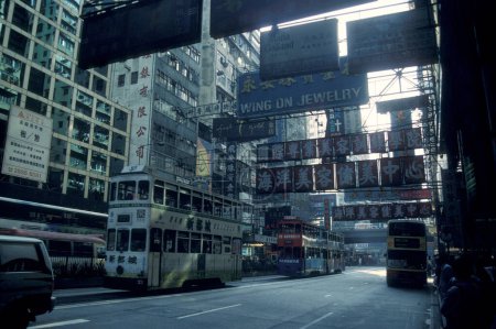 Téléchargez les photos : Une route avec des bâtiments dans le centre de Hongkong dans la ville de Hongkong à Hongkong. Chine, Hongkong, décembre 1996 - en image libre de droit