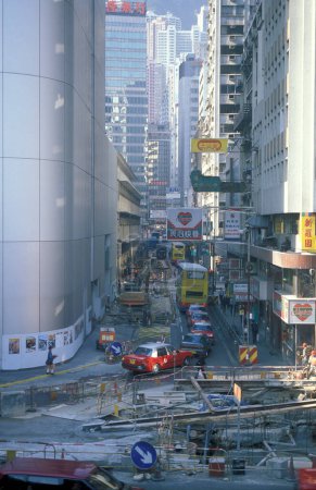 Téléchargez les photos : Une route avec des bâtiments dans le centre de Hongkong dans la ville de Hongkong à Hongkong. Chine, Hongkong, décembre 1996 - en image libre de droit